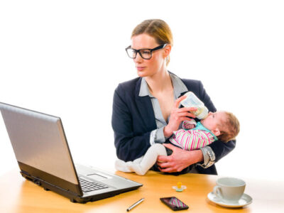 Businesswoman feeding baby